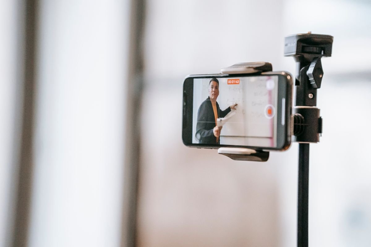 Un enseignant animant un cours en ligne à l'aide d'un smartphone monté sur un