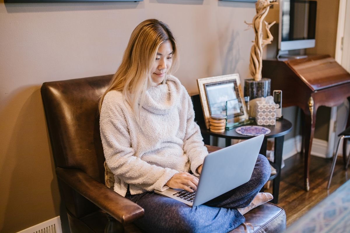 Femme assise sur une chaise utilisant un ordinateur portable, profitant d'un