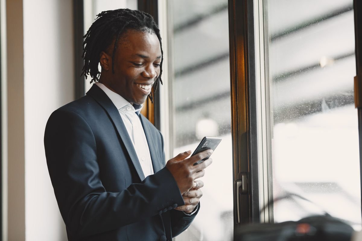 Les avis clients : ce qu’ils valent vraiment Homme afro-américain en tenue professionnelle souriant et utilisant un