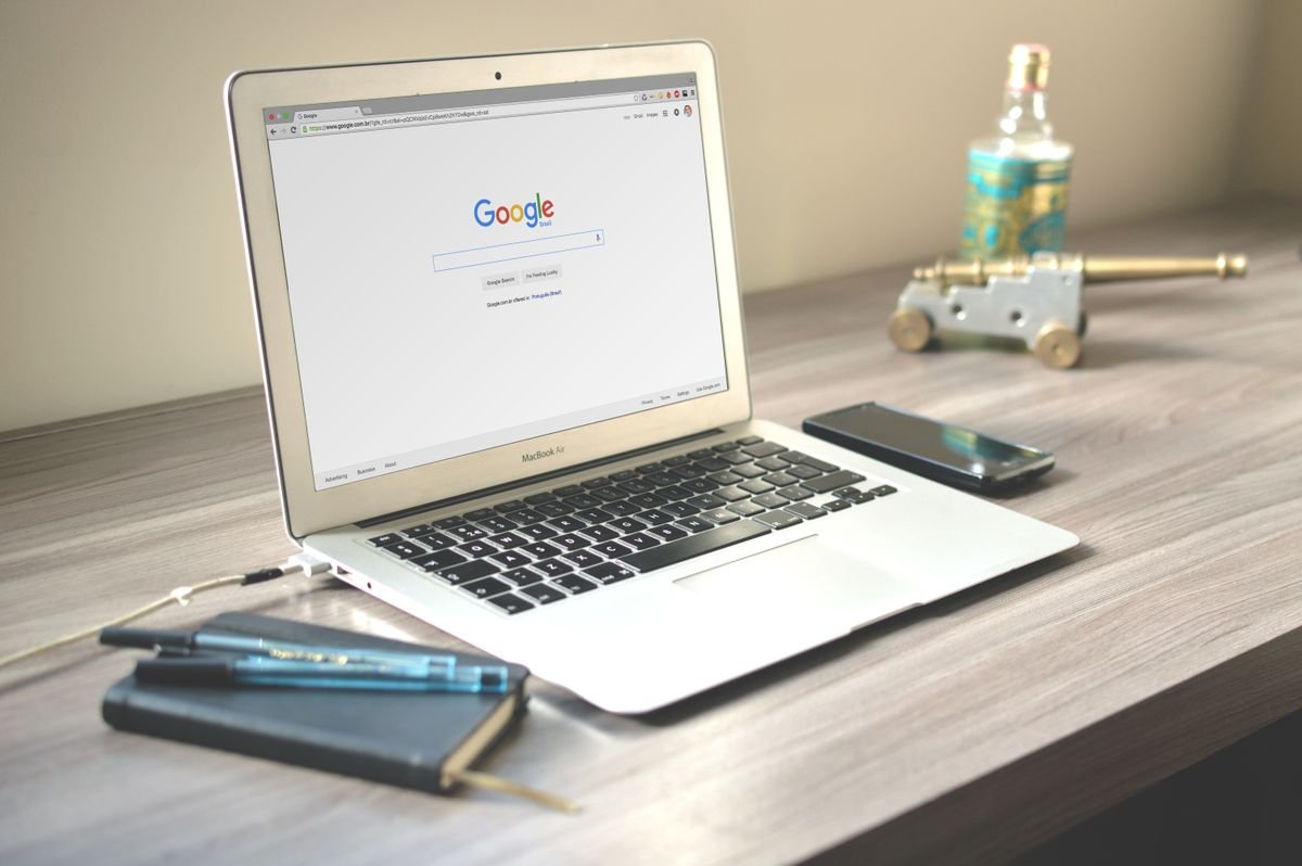 Un bureau soigné avec un ordinateur portable affichant une recherche Google, un