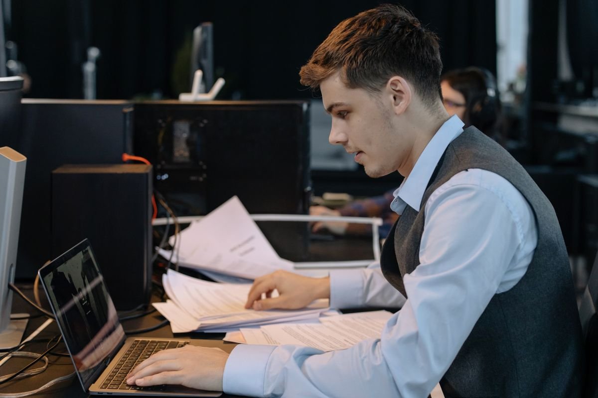 Jeune professionnel masculin concentré sur son travail avec un ordinateur
