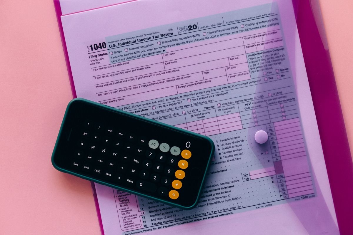 Formulaire fiscal 1040 avec une calculatrice sur un fond rose