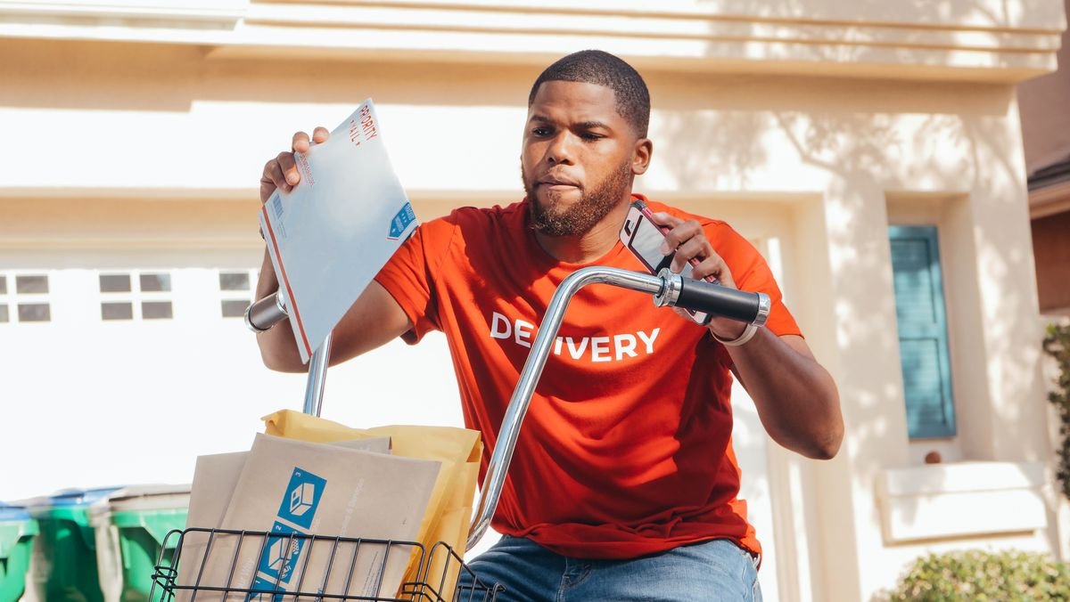 Un homme afro-américain livrant du courrier à vélo en extérieur