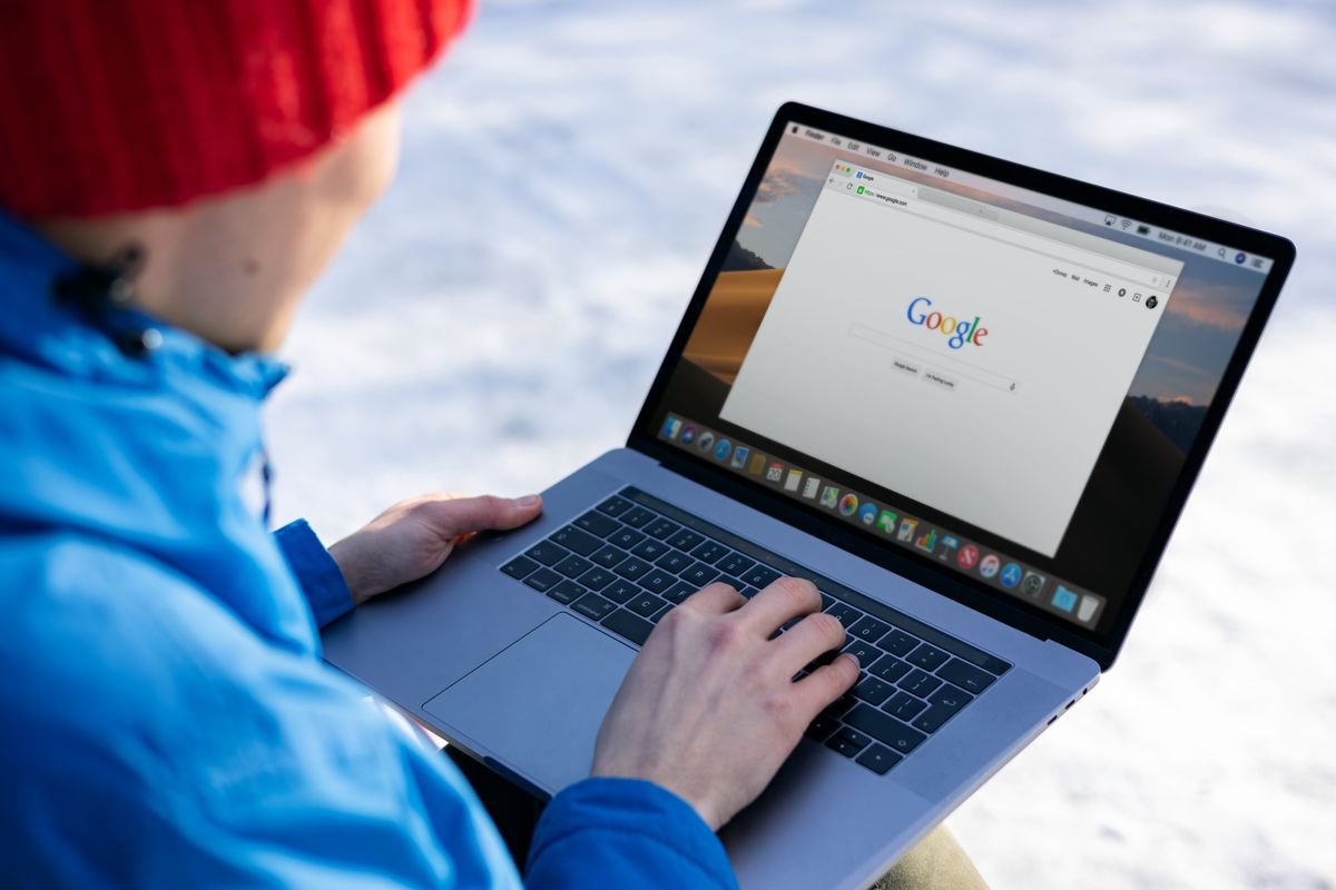 Personne en tenue d'hiver utilisant un ordinateur portable avec une recherche