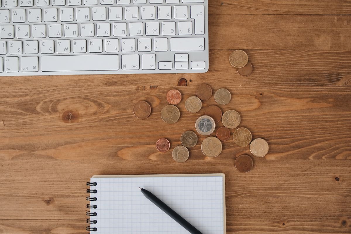Des pièces éparpillées sur un bureau en bois aux côtés d'un clavier et d'un
