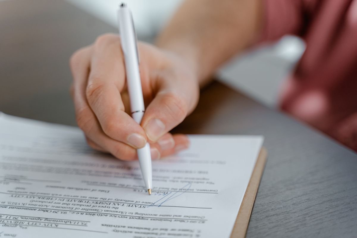 Vue détaillée d'une main écrivant une signature sur un document officiel avec