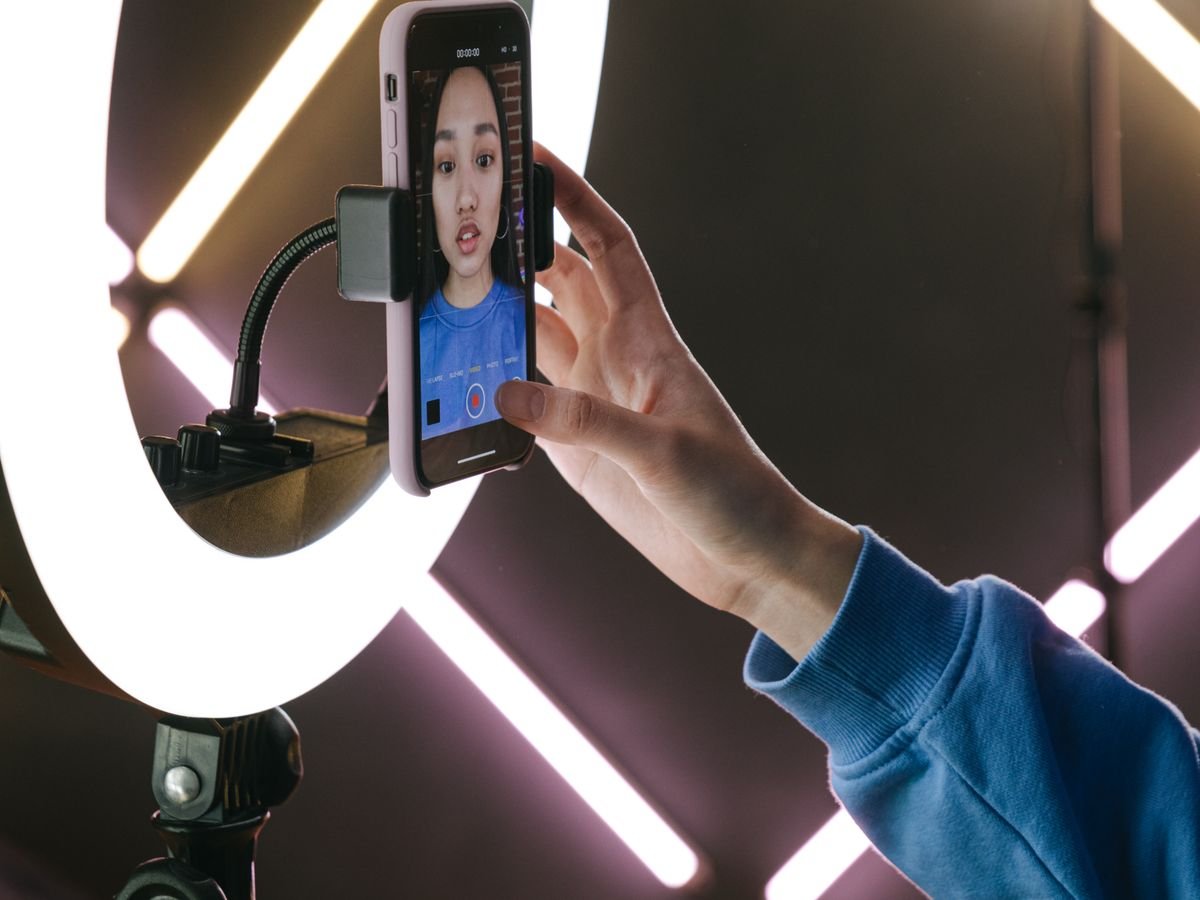 Une main règle un téléphone fixé sur un anneau lumineux