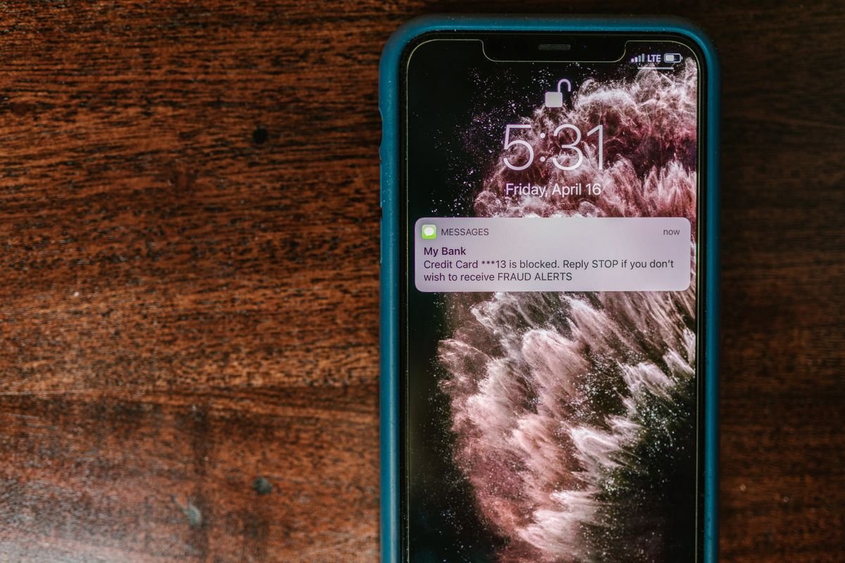 Gros plan d'un smartphone affichant un message d'alerte à la fraude sur une