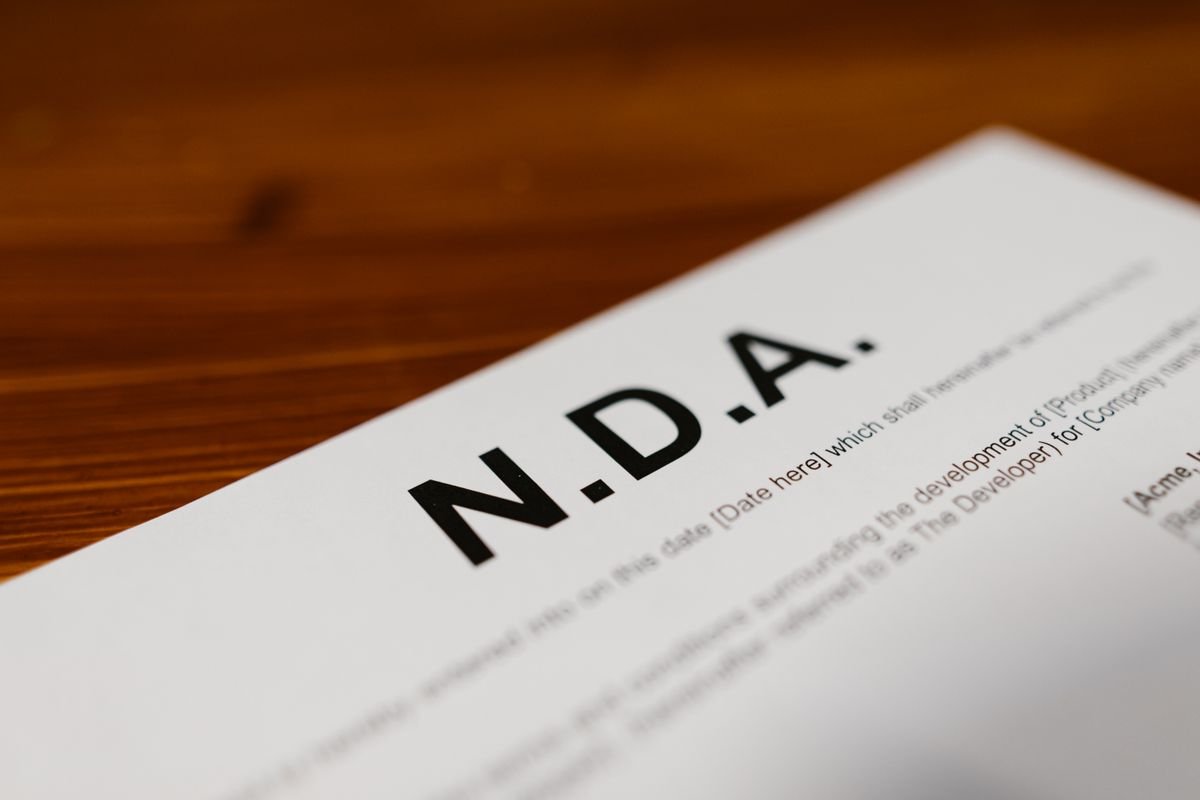 Gros plan d'un document de NDA sur un bureau en bois