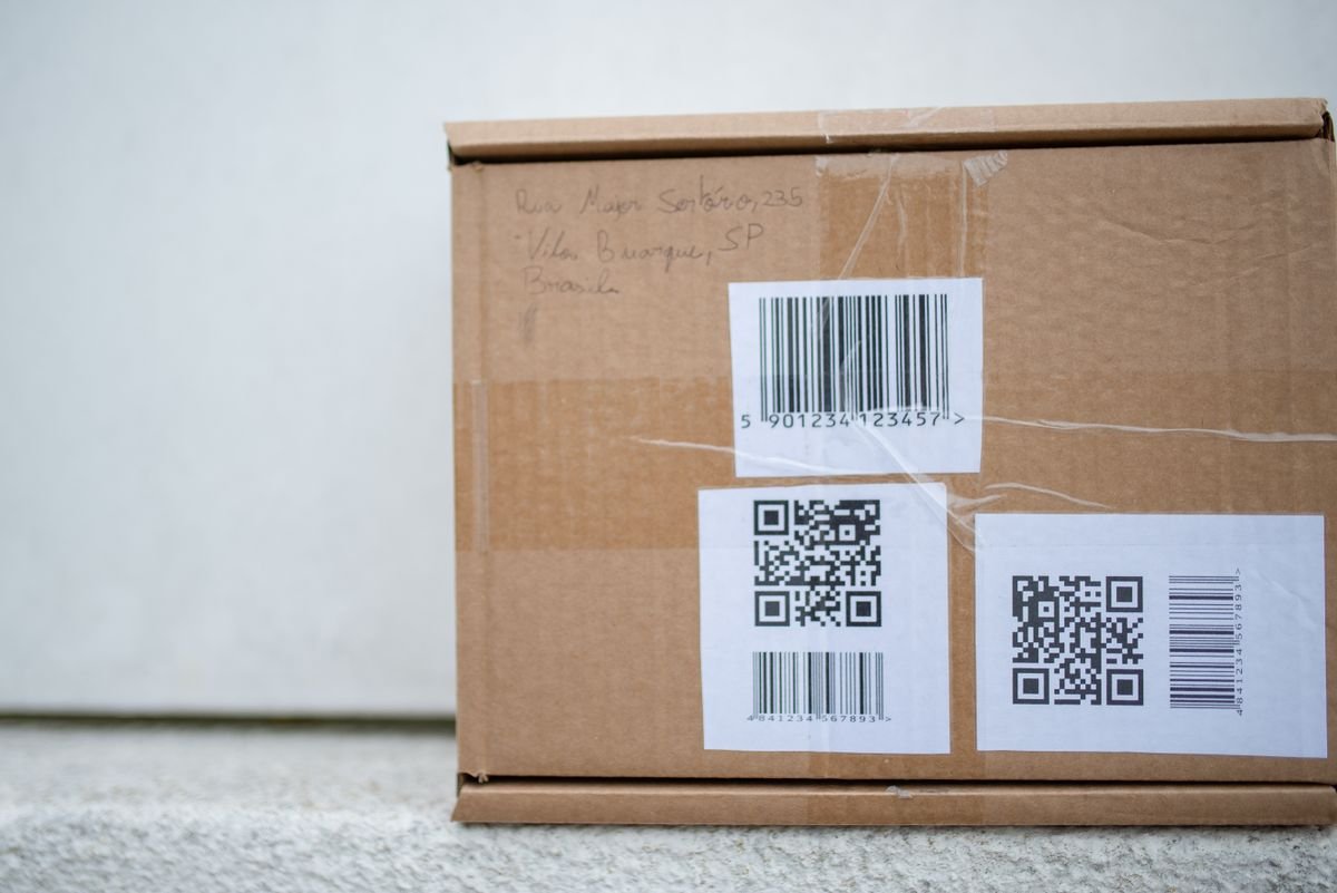 Gros plan d'un colis en carton avec des codes QR et un code-barres