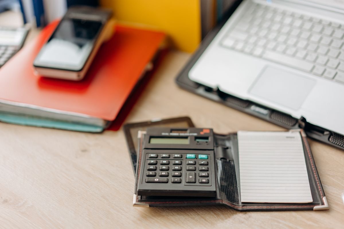 Espace de travail organisé avec une calculatrice, un bloc-notes et un