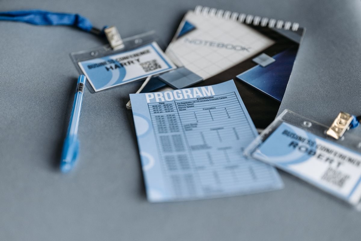 Gros plan sur des matériaux de conférence comprenant des badges, un programme