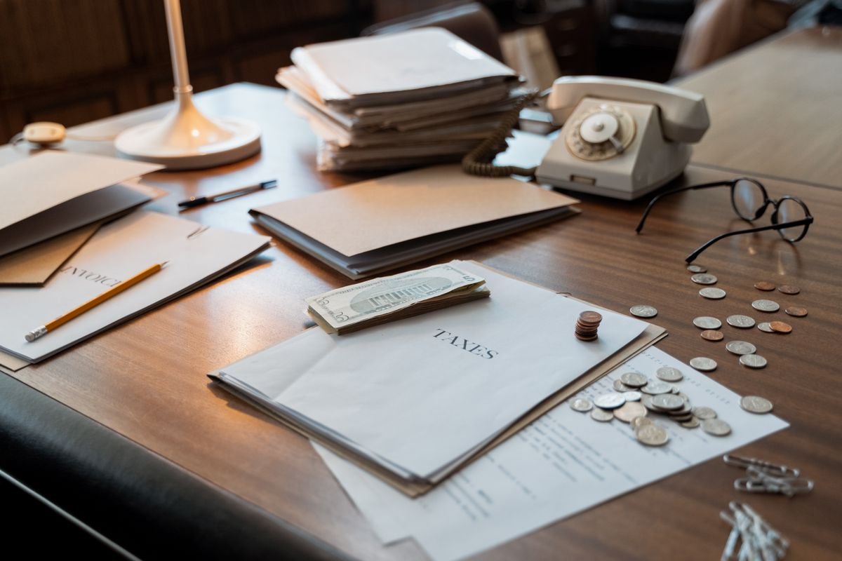 Gros plan d'un bureau avec des documents fiscaux, des pièces de monnaie, des