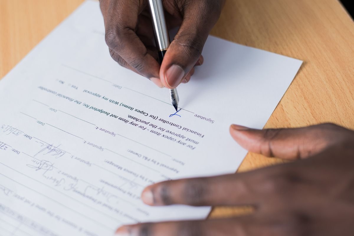 Obligations e-commerce : ce qui a changé depuis 2022 Vue en gros plan de la main d'une personne signant un contrat commercial sur un