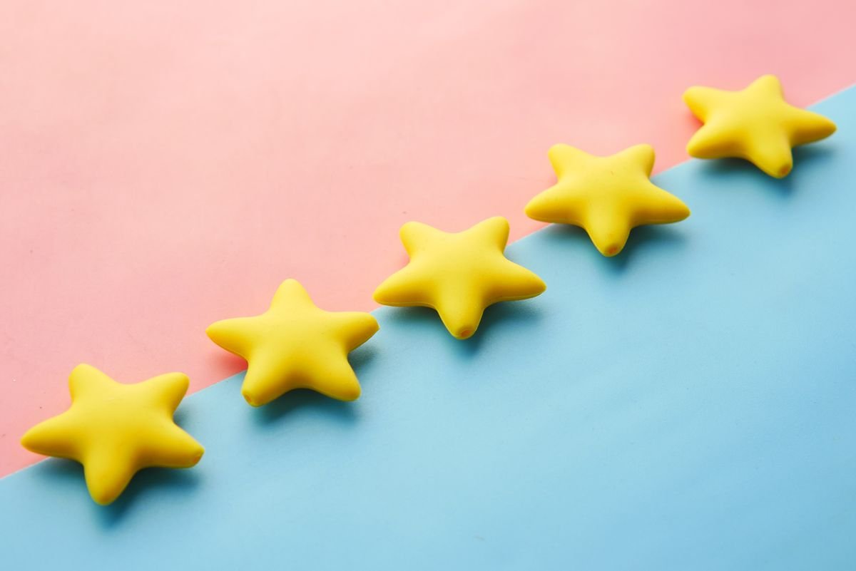 Récolter des avis clients : la méthode qui m'en a apporté 2 189 Étoiles jaunes sur un fond pastel rose et bleu pour un concept d'évaluation ou