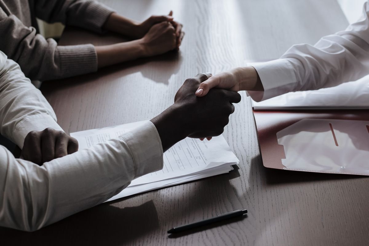 Médiateur de la consommation : l’obligation oubliée Accord commercial avec une poignée de main sur des documents de contrat à une