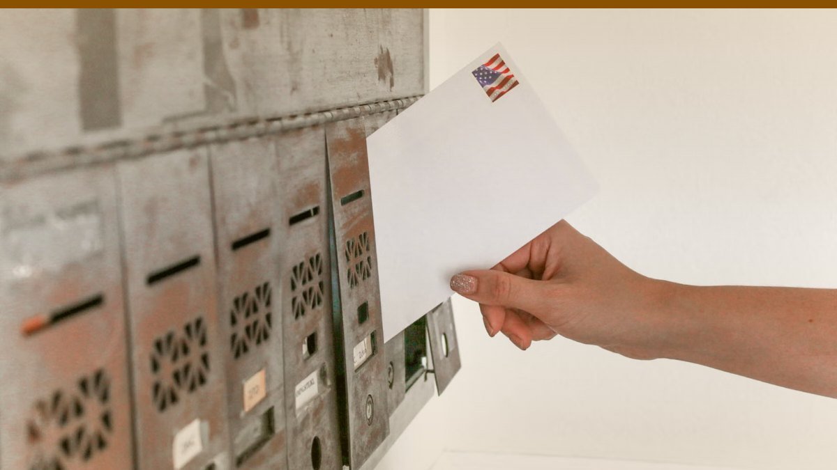 Main deposant un petit colis dans une boite aux lettres