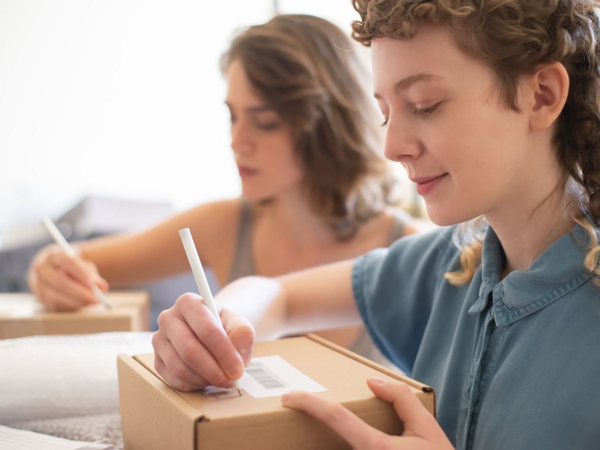 Deux femmes emballent des commandes dans des cartons