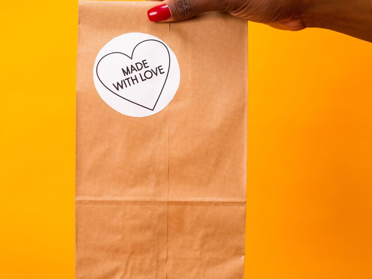 Des mains tiennent un sac en papier kraft