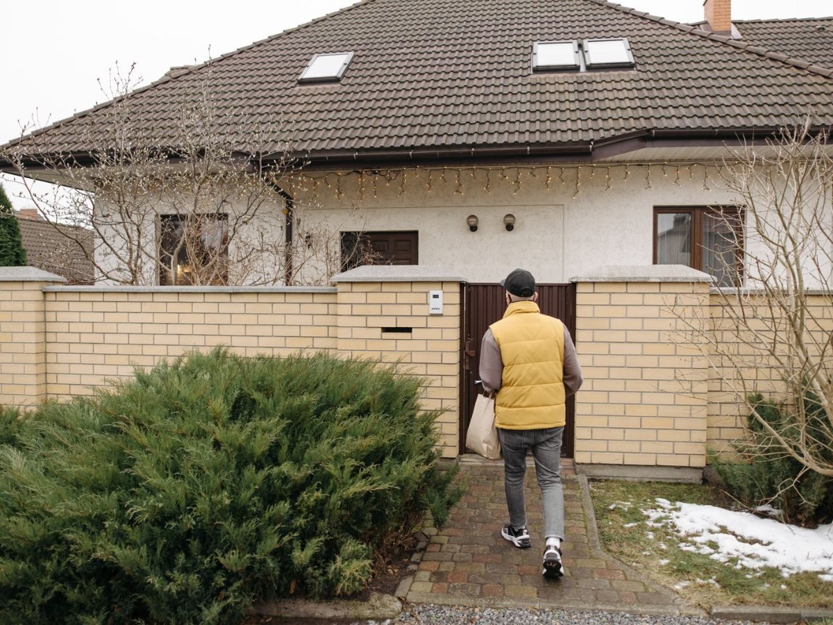 Un livreur apporte un colis a la porte d une maison